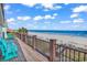 Wooden deck with ocean views, railing, and blue Adirondack chairs at 969 S Waccamaw Dr., Garden City Beach, SC 29576