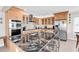 Modern kitchen featuring wood cabinets, granite countertops, backsplash, and stainless steel appliances at 969 S Waccamaw Dr., Garden City Beach, SC 29576