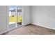 Bedroom with wood-look floors and sliding glass door leading to the backyard at 1004 Sentinel Ct., Little River, SC 29566