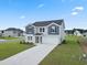 Attractive two-story home with gray siding, black shutters, and a long concrete driveway at 1013 Kinness Dr., Conway, SC 29527
