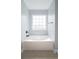 Bathroom featuring tile floors, a large soaking tub beneath a window, and neutral paint at 1031 Snowberry Dr., Longs, SC 29568