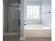 Modern bathroom featuring a soaking tub, separate shower, and natural light from a window at 1031 Snowberry Dr., Longs, SC 29568