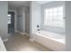 Relax in this bathroom featuring a large soaking tub, a window, and ceramic tile flooring at 1031 Snowberry Dr., Longs, SC 29568