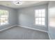 Neutrally painted bedroom featuring carpet and two bright windows at 1031 Snowberry Dr., Longs, SC 29568