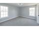 Neutrally painted bedroom featuring carpet and two bright windows at 1031 Snowberry Dr., Longs, SC 29568