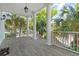 Expansive balcony space with white columns and wood flooring, offers a relaxing spot with pleasant neighborhood views at 107 Waterway Crossing Ct., Little River, SC 29566