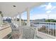 White wicker chairs adorn a covered balcony overlooking waterfront views and blue skies at 107 Waterway Crossing Ct., Little River, SC 29566