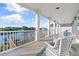 Relaxing waterfront balcony with white columns, wicker chairs and water views at 107 Waterway Crossing Ct., Little River, SC 29566