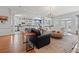 An open-concept living room and kitchen area with hardwood floors, an area rug, and a charming chandelier at 107 Waterway Crossing Ct., Little River, SC 29566