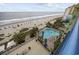 Breathtaking aerial shot of the beach, a pool with chaise lounges, palm trees, and nearby beach access at 1105 S Ocean Blvd. # 724, Myrtle Beach, SC 29577