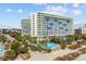 Aerial view of a beachfront hotel with a swimming pool and lush landscaping at 1105 S Ocean Blvd. # 724, Myrtle Beach, SC 29577