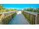 Scenic beach access boardwalk through lush dune vegetation leading to sandy shores and ocean views at 1207 South Ocean Blvd. # 51106, Myrtle Beach, SC 29577