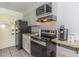 Efficient kitchen with a black refrigerator, electric stove, microwave, and white cabinets at 1207 South Ocean Blvd. # 51106, Myrtle Beach, SC 29577