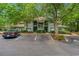 Two-story condo building with green siding and balcony, nestled among mature trees in a landscaped community at 1221 Tidewater Dr. # 2811, North Myrtle Beach, SC 29582