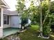 Backyard featuring a quaint patio, lush greenery, stone planter edging and a well-maintained lawn at 131 Goodale Dr., Longs, SC 29568