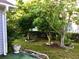 Well maintained backyard with stone planter edging, beautiful mature trees, and green grass at 131 Goodale Dr., Longs, SC 29568