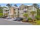 Aerial view shows a multi-story building featuring balconies, landscaping, and convenient parking spaces at 144 Puffin Dr. # 2A, Pawleys Island, SC 29585