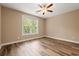 Cozy bedroom features hardwood floors, a ceiling fan, and a large window for natural light at 144 Puffin Dr. # 2A, Pawleys Island, SC 29585