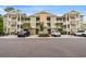 Apartment complex with multiple balconies, lush landscaping, and convenient parking for residents and visitors at 144 Puffin Dr. # 2A, Pawleys Island, SC 29585