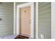 Unit front door with a welcome mat and the building's neutral-toned facade at 144 Puffin Dr. # 2A, Pawleys Island, SC 29585