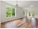 Bright living room features hardwood floors, neutral paint, large windows with view, and patio doors at 144 Puffin Dr. # 2A, Pawleys Island, SC 29585