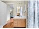 Bathroom with sink, mirror, and nearby door to a bedroom with a ceiling fan, offering comfort and convenience at 17 South Oak Dr., Surfside Beach, SC 29575