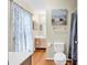 Well-maintained bathroom with a vanity, framed mirror, and bathtub shower with decorative curtains at 17 South Oak Dr., Surfside Beach, SC 29575