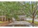 Exterior view of a coastal home with a spacious carport, covered porch and deck surrounded by trees at 17 South Oak Dr., Surfside Beach, SC 29575