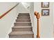 Carpeted staircase featuring wood handrail and banister, leading to the upper level at 17 South Oak Dr., Surfside Beach, SC 29575