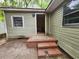 Rear view of the home featuring olive green siding, a brick stairway and a doorway at 1744 John St., Conway, SC 29527