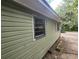 Angle side view of home's exterior with olive green siding and white trim around the windows at 1744 John St., Conway, SC 29527