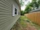 Side view of home's exterior with olive green siding and white trim around the windows at 1744 John St., Conway, SC 29527