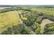Overhead view of a forested property near farmland, divided by a long road at 1895 Bucksville Dr., Conway, SC 29527