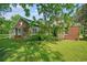 Brick home with screened porch, partially covered in vines, surrounded by lush greenery at 1895 Bucksville Dr., Conway, SC 29527