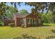 A quaint brick home with a lush green lawn surrounded by mature trees and landscaping at 1895 Bucksville Dr., Conway, SC 29527