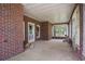 A spacious brick porch featuring windows and white accents creates an airy and inviting atmosphere at 1895 Bucksville Dr., Conway, SC 29527