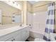 Well-lit bathroom features a vanity with white cabinetry, a sink, and a shower-tub combo with a striped curtain at 200 53Rd Ave. N # 209, North Myrtle Beach, SC 29582