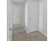 Hallway with neutral colored tile flooring, white walls and trim, and paneled doors at 2005 Havens Dr., North Myrtle Beach, SC 29582