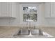 Bright kitchen featuring a double stainless steel sink with a window overlooking a tree-filled landscape at 2005 Havens Dr., North Myrtle Beach, SC 29582