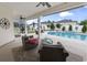 Relaxing outdoor patio featuring comfortable seating, view of the pool, lush landscaping, and a privacy fence at 2191 Deerfield Ave., Surfside Beach, SC 29575