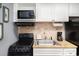 Efficient kitchen with microwave, range, sink, attractive backsplash, and granite-style countertops at 2311 South Ocean Blvd. # 559, Myrtle Beach, SC 29577