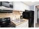 Compact kitchen features white cabinets, stainless steel sink, and a black refrigerator and oven at 2311 South Ocean Blvd. # 559, Myrtle Beach, SC 29577