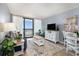 Bright living room with sofa, coffee table, TV and sliding door to balcony at 2311 South Ocean Blvd. # 559, Myrtle Beach, SC 29577