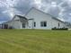 Exterior shot of a home with white siding, a covered patio, and a spacious lawn at 240 Wagner Cir., Conway, SC 29526