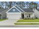 Charming home with white siding, blue trim, brick accents, manicured lawn, and a two-car garage at 2405 Capri Court, Conway, SC 29527