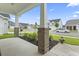 Covered front porch showing neighborhood, brick columns, green bushes and mulch at 2405 Capri Court, Conway, SC 29527