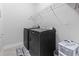 Bright laundry room with dark washer and dryer, wire rack shelving, and cream colored tiled floors at 2405 Capri Court, Conway, SC 29527