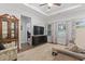 Comfortable living room with ceiling fan, large windows, modern TV and cabinet and hardwood flooring at 2405 Capri Court, Conway, SC 29527