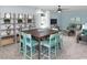 Spacious living room features a large entertaining table, custom shelving, and multiple sitting areas at 2429 Watershed Way, Longs, SC 29568