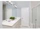 Well-lit bathroom featuring double sinks, a large mirror, and a glass-enclosed shower at 2500 Watershed Way, Longs, SC 29568